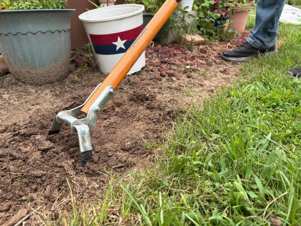 Flower-bed soil being cultivated by hand